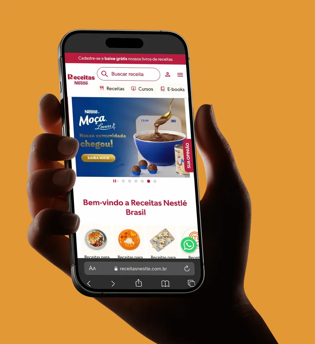 Mão segurando um celular com o site Receitas Nestlé aberto