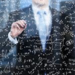 A business person is writing down math formulas on the glass screen in the evening modern panoramic office.